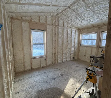 Home interior insulated with spray foam, snow visible through the windows — insulation built for northern winters