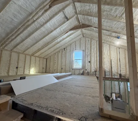 Attic with spray foam insulation covering the roof deck and walls in a central Pennsylvania home