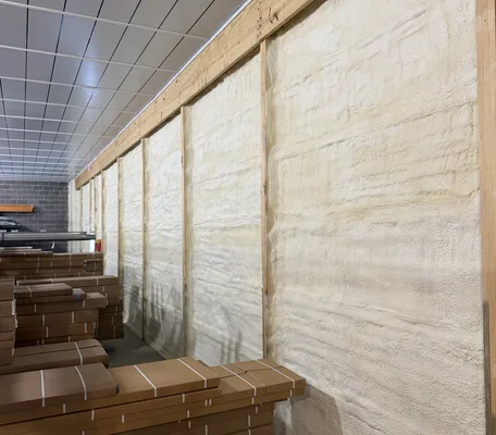Spray foam insulation filling framed wall cavities of a new construction building in central Pennsylvania