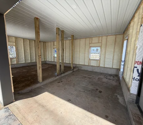 Spray foam insulation filling the stud wall cavities of a new garage build in central Pennsylvania