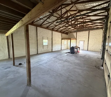 Pole barn interior with walls and roof deck fully insulated with spray foam by Central PA Spray Foam